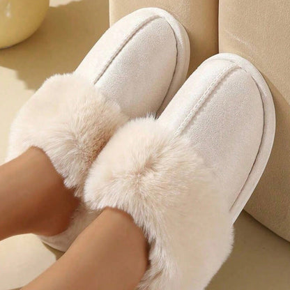 Beige faux fur slippers shown close up while being worn