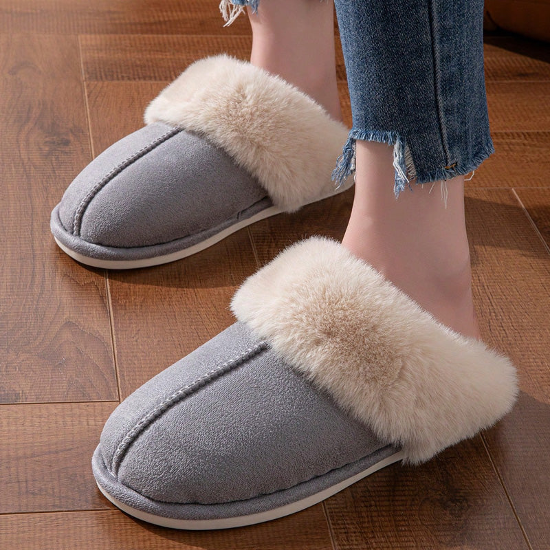 Dark grey faux fur slippers worn on an indoor floor