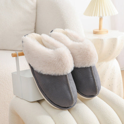 Dark grey faux fur slippers displayed on a stool