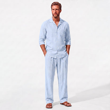 Blue men's two piece linen-blend set with Grandad collar shirt and straight-leg trousers, front model view with hands in pockets