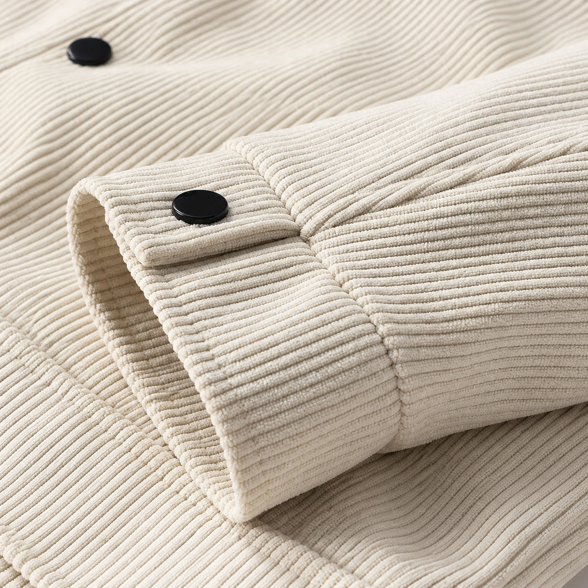 Ecru corduroy jacket sleeve showing the press-stud cuff and cord texture