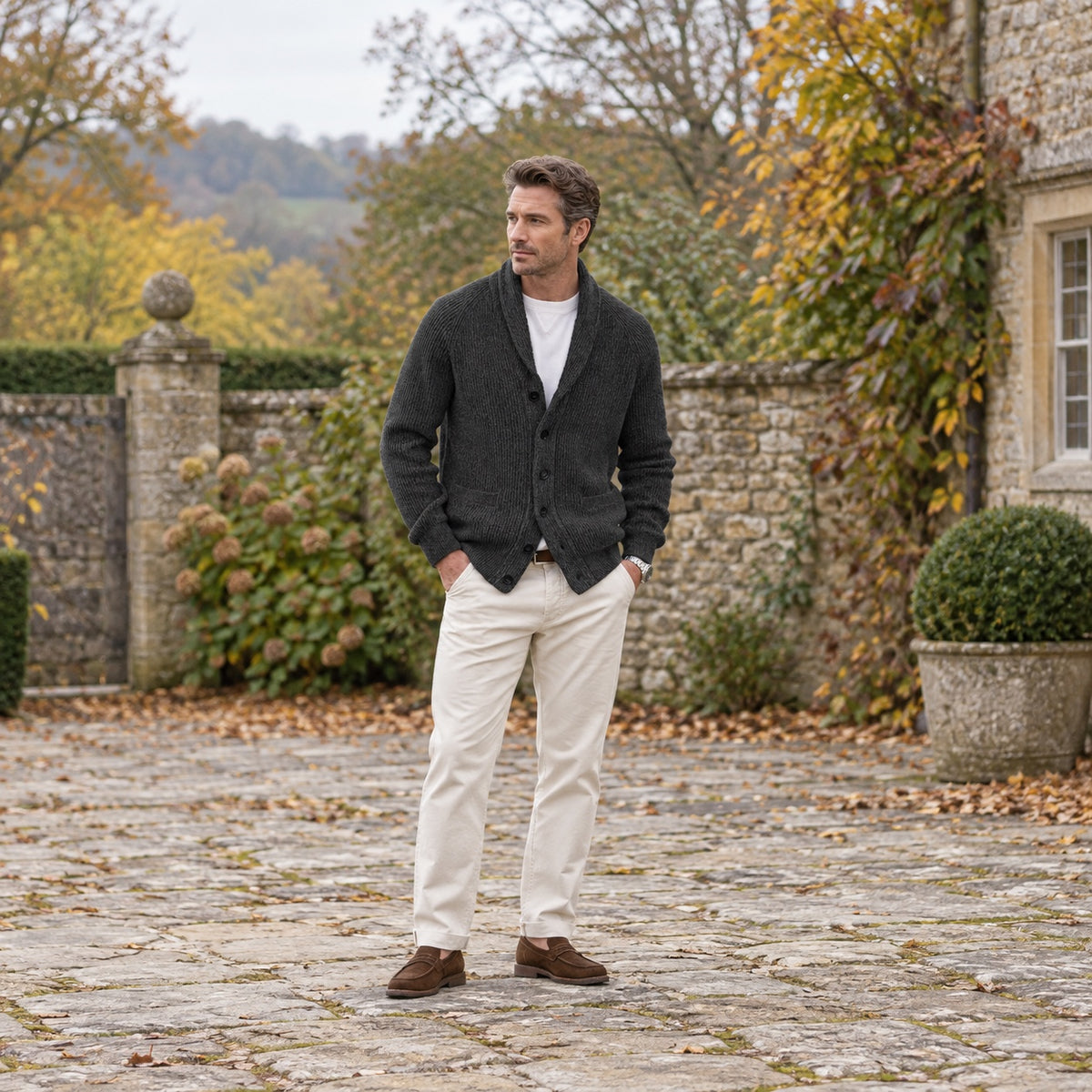 Man wearing a charcoal cardigan with trousers in an autumn outdoor setting