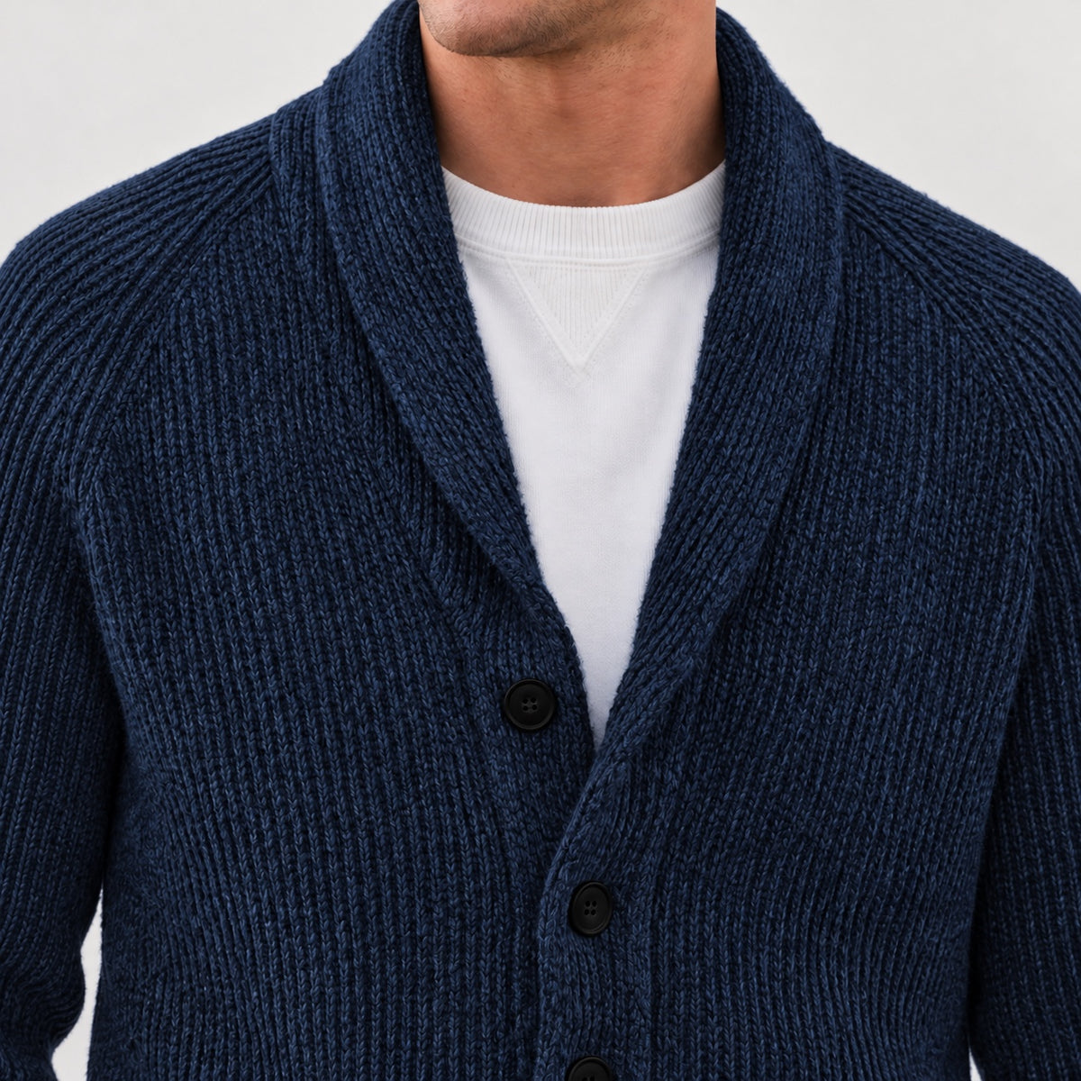 Shawl collar and upper front button detail on the navy cardigan