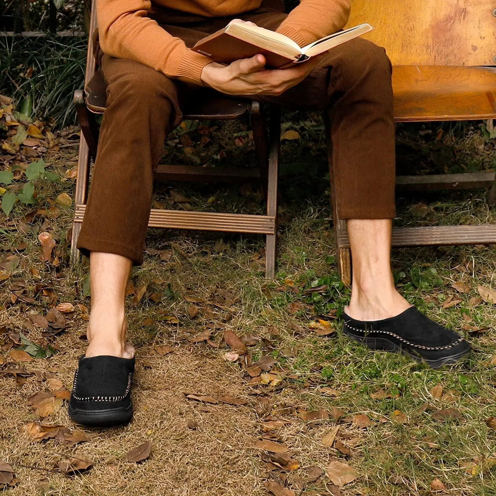 Black moccasin house slippers worn while reading on a garden bench