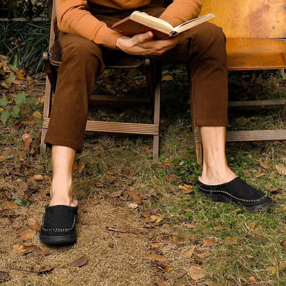 Black moccasin house slippers worn while reading on a garden bench