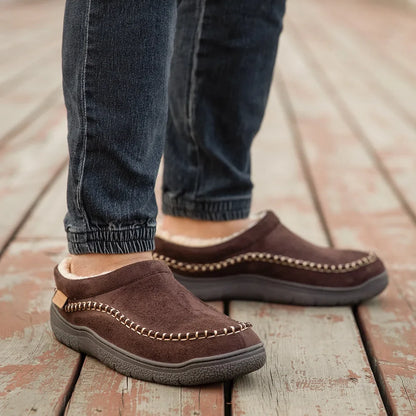 Coffee-brown house slippers worn with jeans on wooden decking