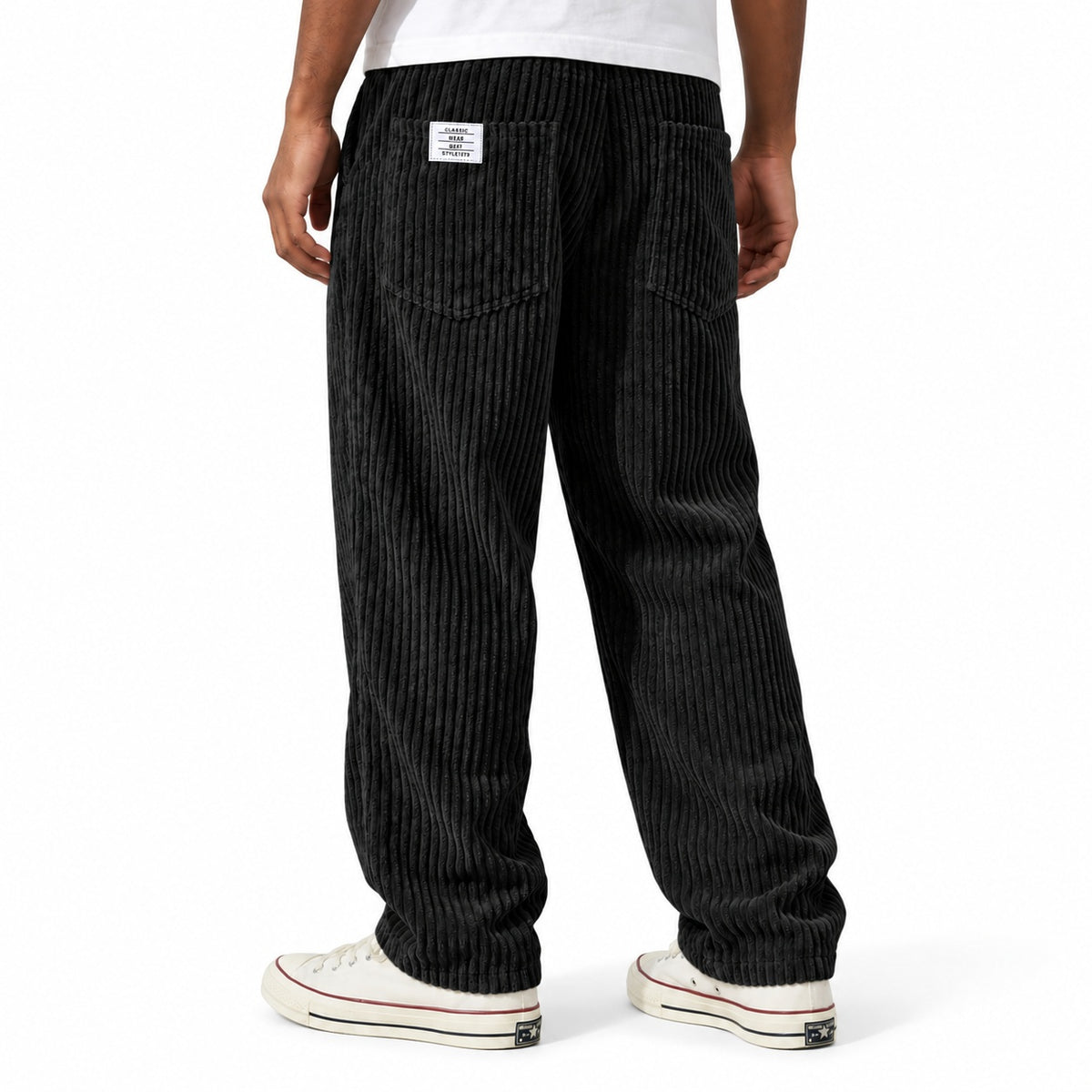 Black ribbed straight-leg trousers shown from the rear three-quarter, with elasticated waist and rear patch pockets