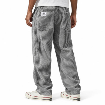 Grey ribbed straight-leg trousers shown from the rear three-quarter, with elasticated waist and rear patch pockets