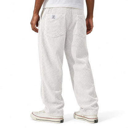 White ribbed straight-leg trousers shown from the rear three-quarter, with elasticated waist and rear patch pockets