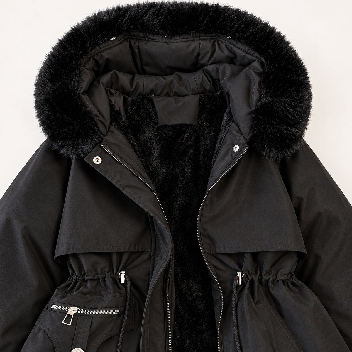 Close view of the black parka’s soft-trimmed hood, plush inner lining, layered chest panels and drawcord waist.