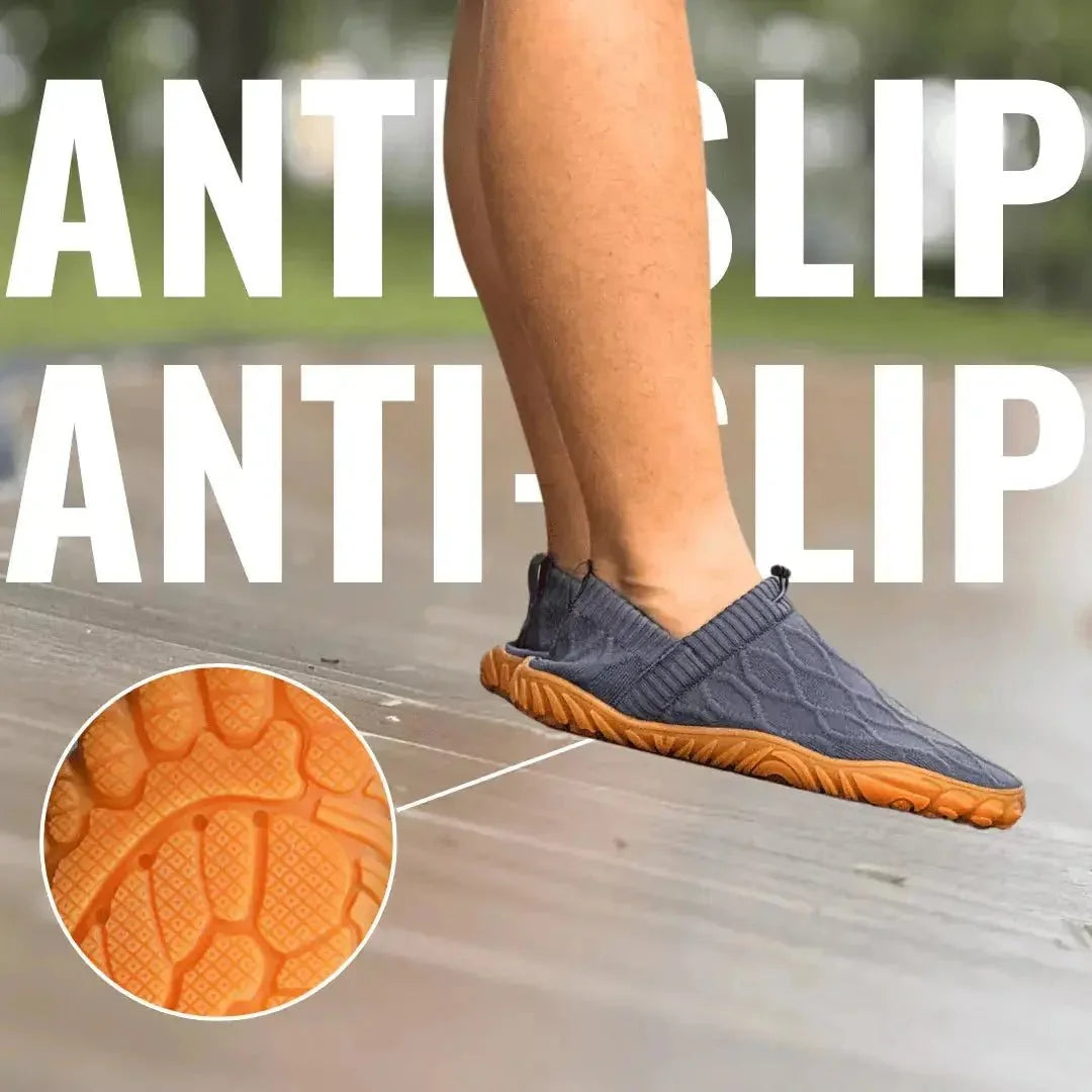Grey slip-on shoe worn outdoors with orange outsole tread detail