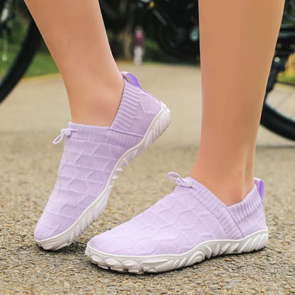 Purple barefoot-style slip-on shoes worn outdoors with a broad rounded toe shape