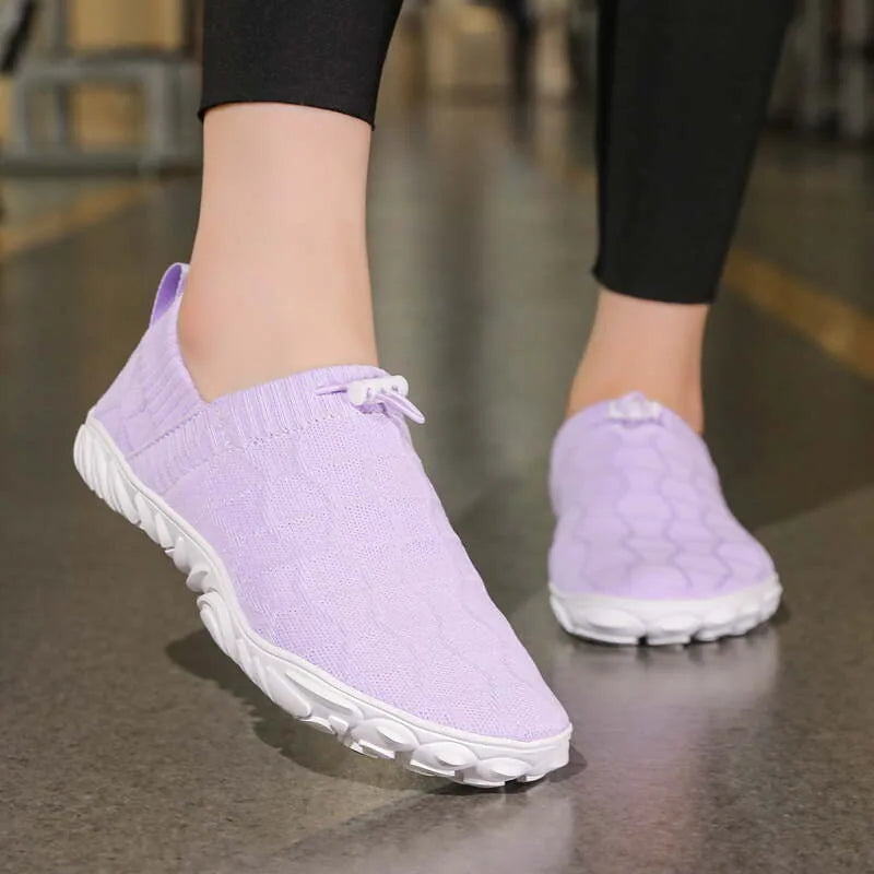 Purple barefoot-style slip-on shoes worn indoors, front view showing the broad rounded toe shape