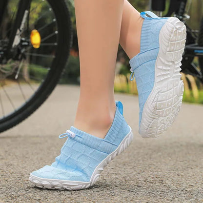 Light blue barefoot-style shoe worn with broad rounded outsole and forefoot visible