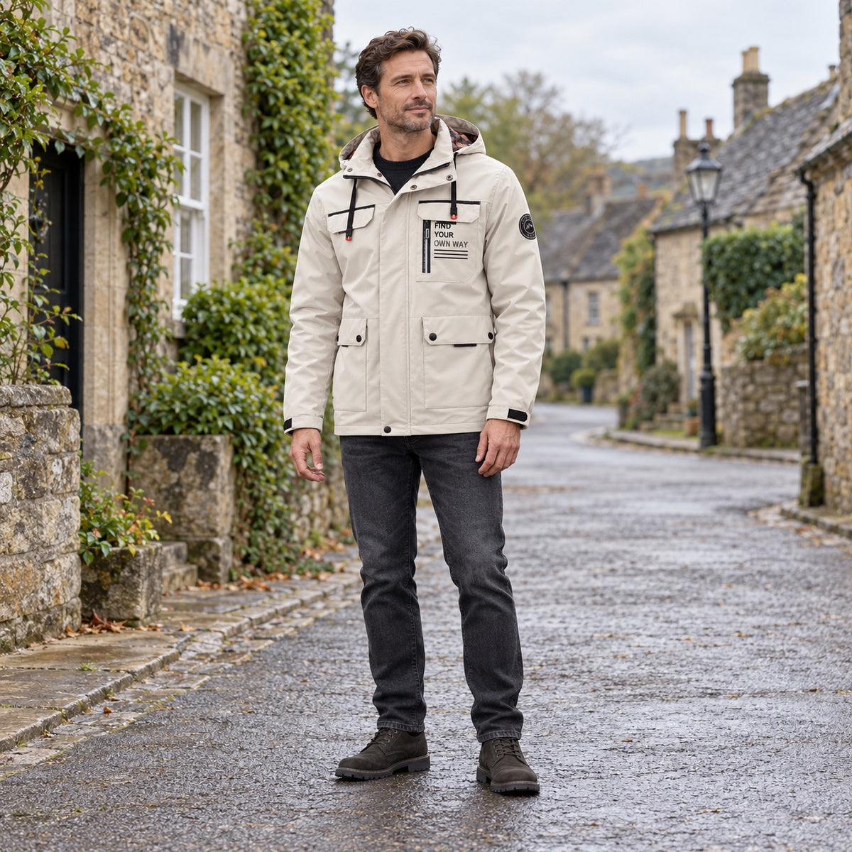 Man wearing the Stone utility jacket with charcoal jeans in a complete head-to-boots village scene.