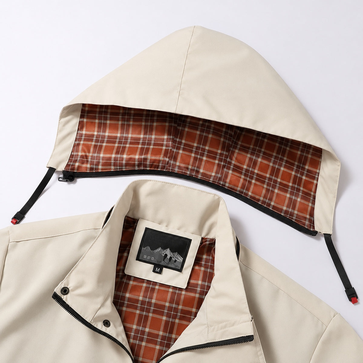 Stone utility jacket with its checked hood detached above the stand collar.
