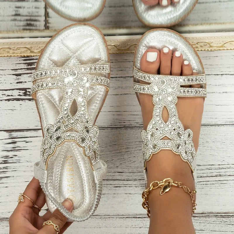 Silver embellished sandals for women, pair on pale wood background