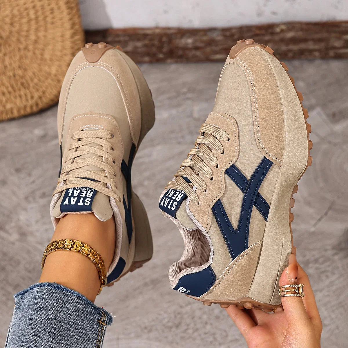 Women's beige and navy walking trainers viewed from above on foot