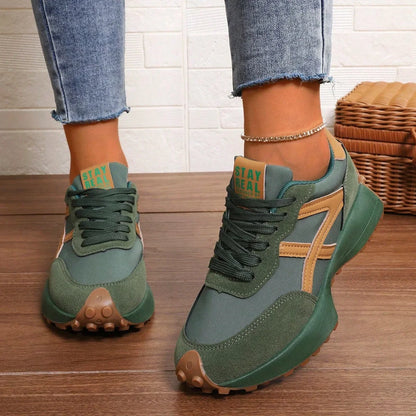 Women's green and orange walking trainers worn from the front