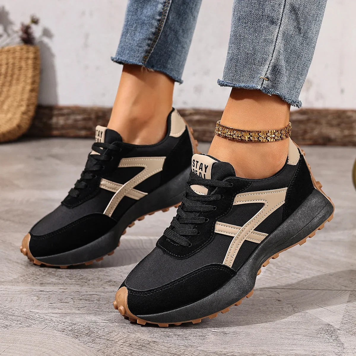 Women's black and cream walking trainers worn from the side
