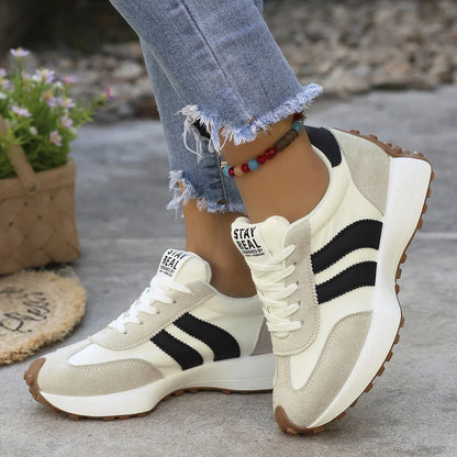 Women's white and black walking trainers worn in side profile