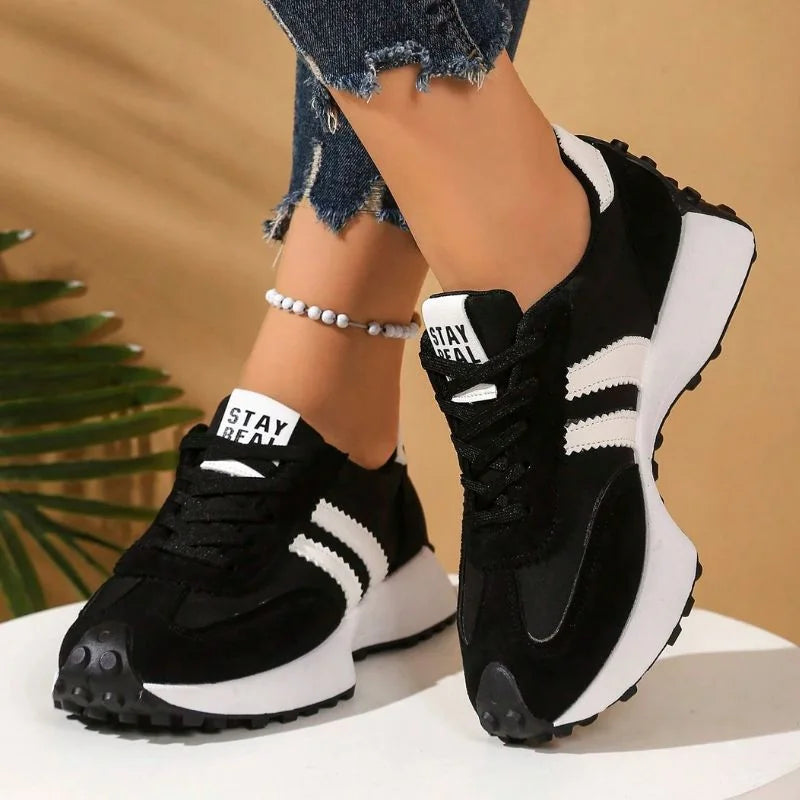 Women's black and white walking trainers in a front three-quarter view