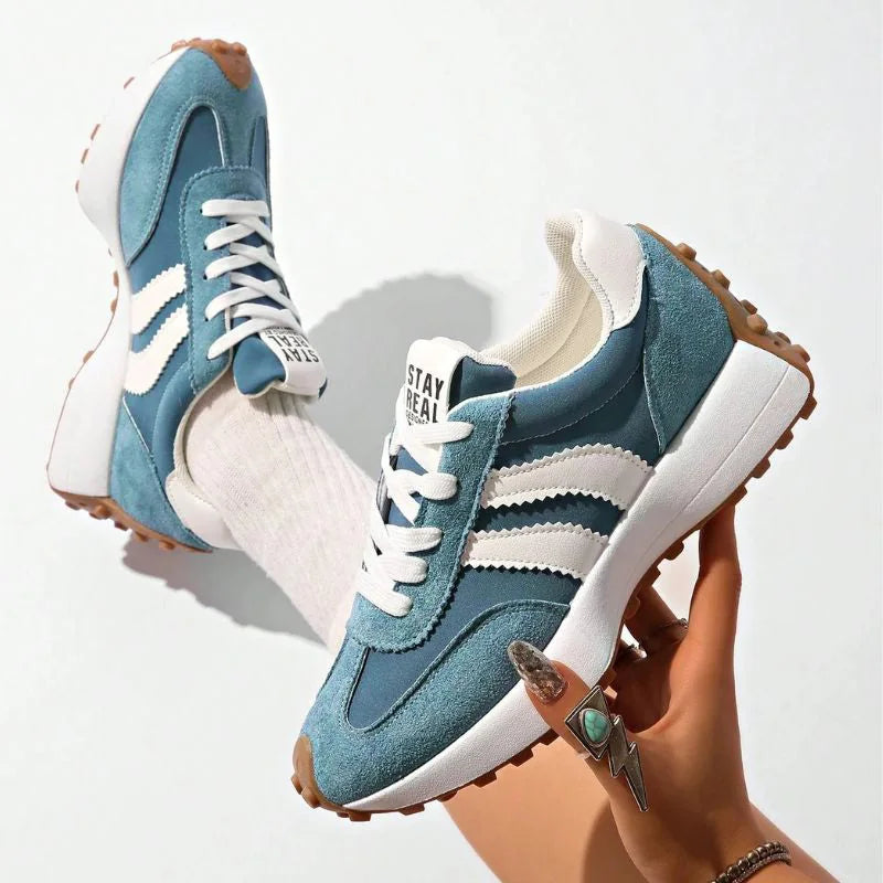 Women's blue and white walking trainers shown from the side and held upright