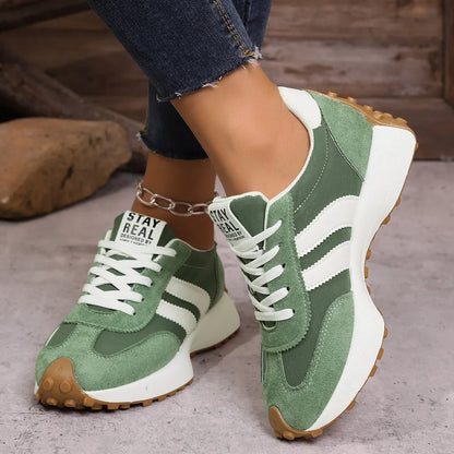 Women's green and white walking trainers worn from the front