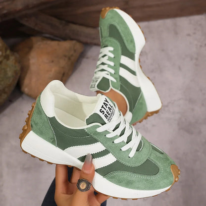Women's green and white walking trainers shown on foot and held from the side