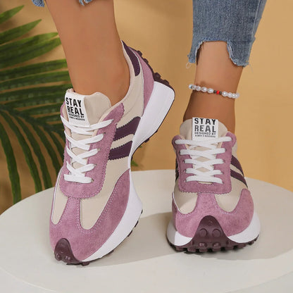 Women's pink, cream and purple walking trainers worn from the front