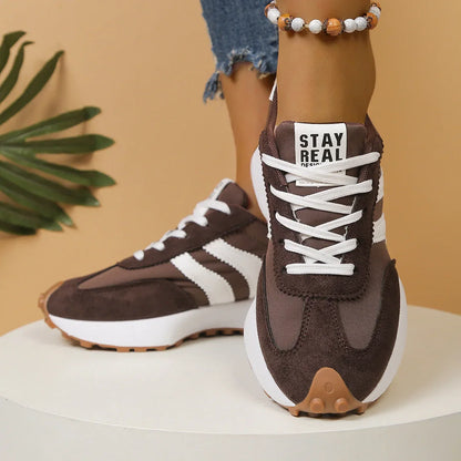 Women's brown and white walking trainers worn from the front