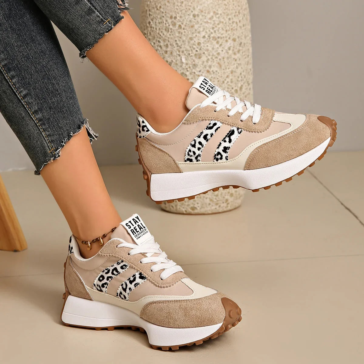 Women's beige and white walking trainers with leopard-print accents, side view