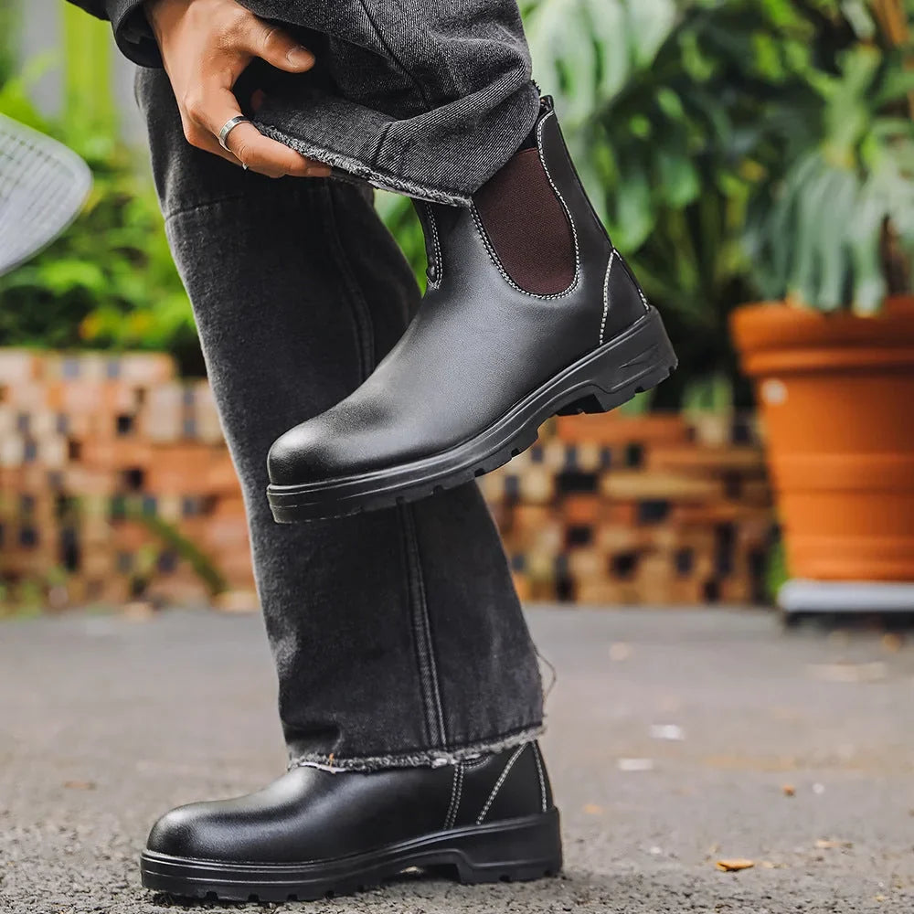 Black Chelsea boots worn outdoors with dark jeans, side view