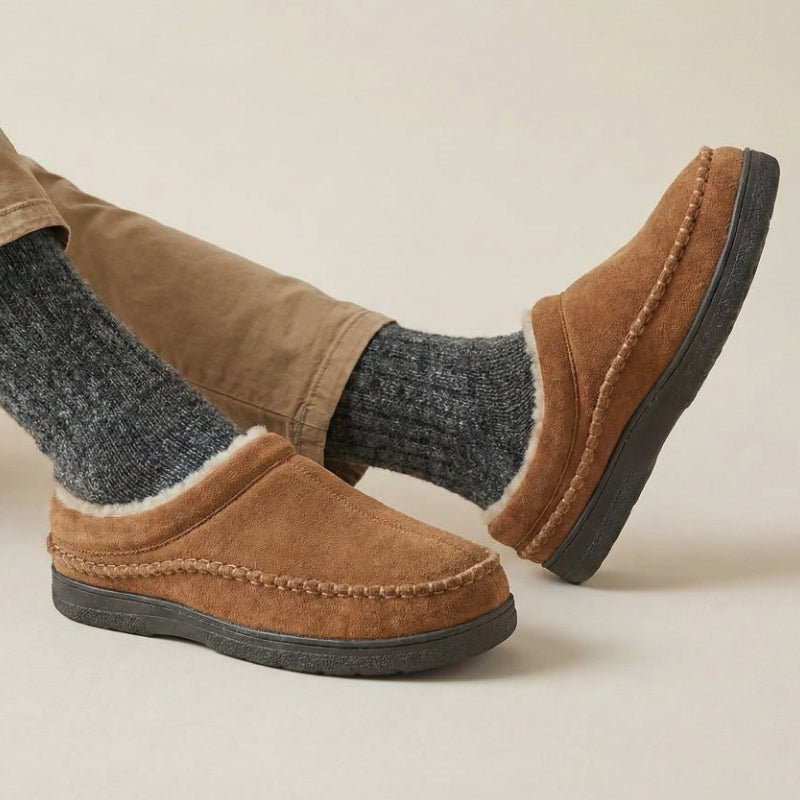 Brown moccasin slippers shown from the side while worn indoors