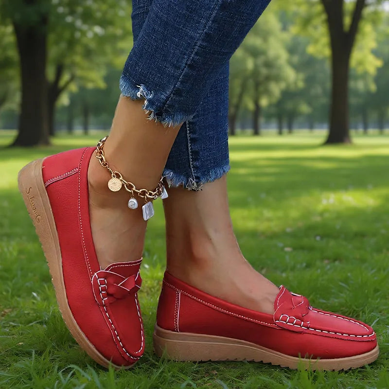 Red loafers for women with braided vamp detail, on-foot park view