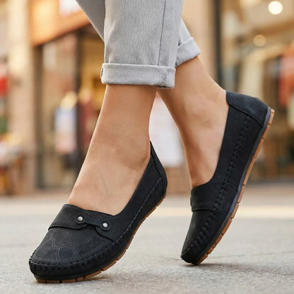 Women's black loafers shown on foot