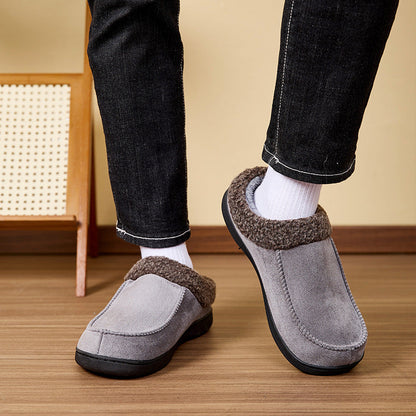Auldweave Men’s warm wide fit winter slippers. grey slippers with brown trim worn indoors on a wooden floor.