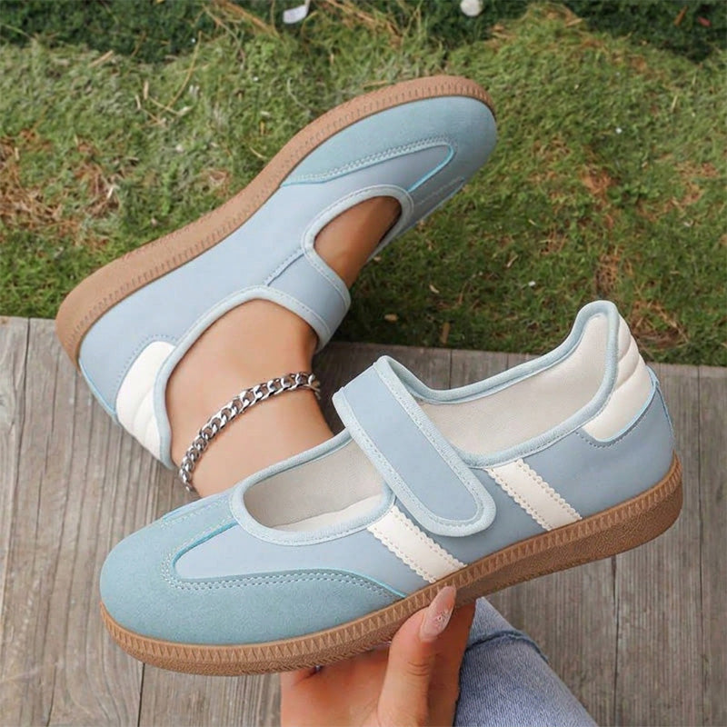Light blue women's Mary Jane trainers with white stripes, showing the strap and gum sole