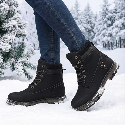 Faux-fur-lined winter ankle boots – black pair worn in snow