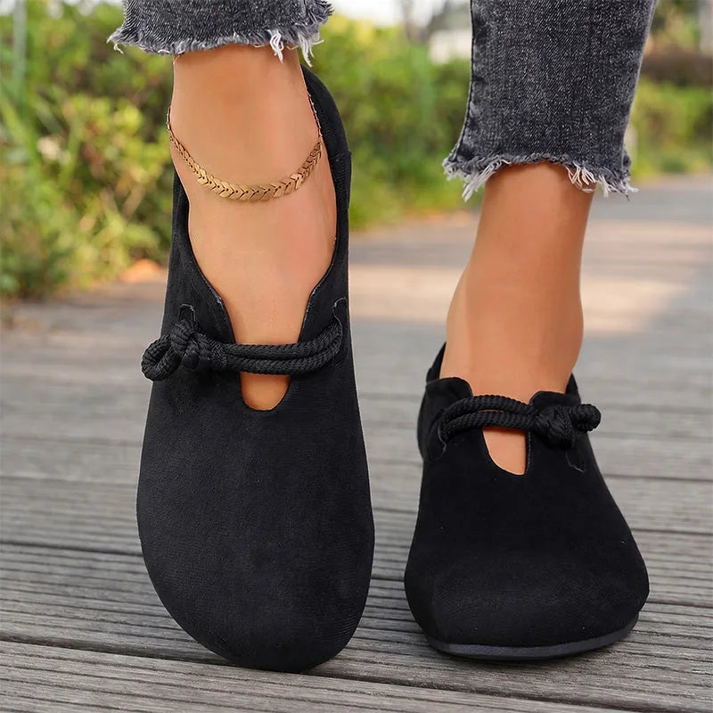 Black comfort flats with bow detail, front on-foot view