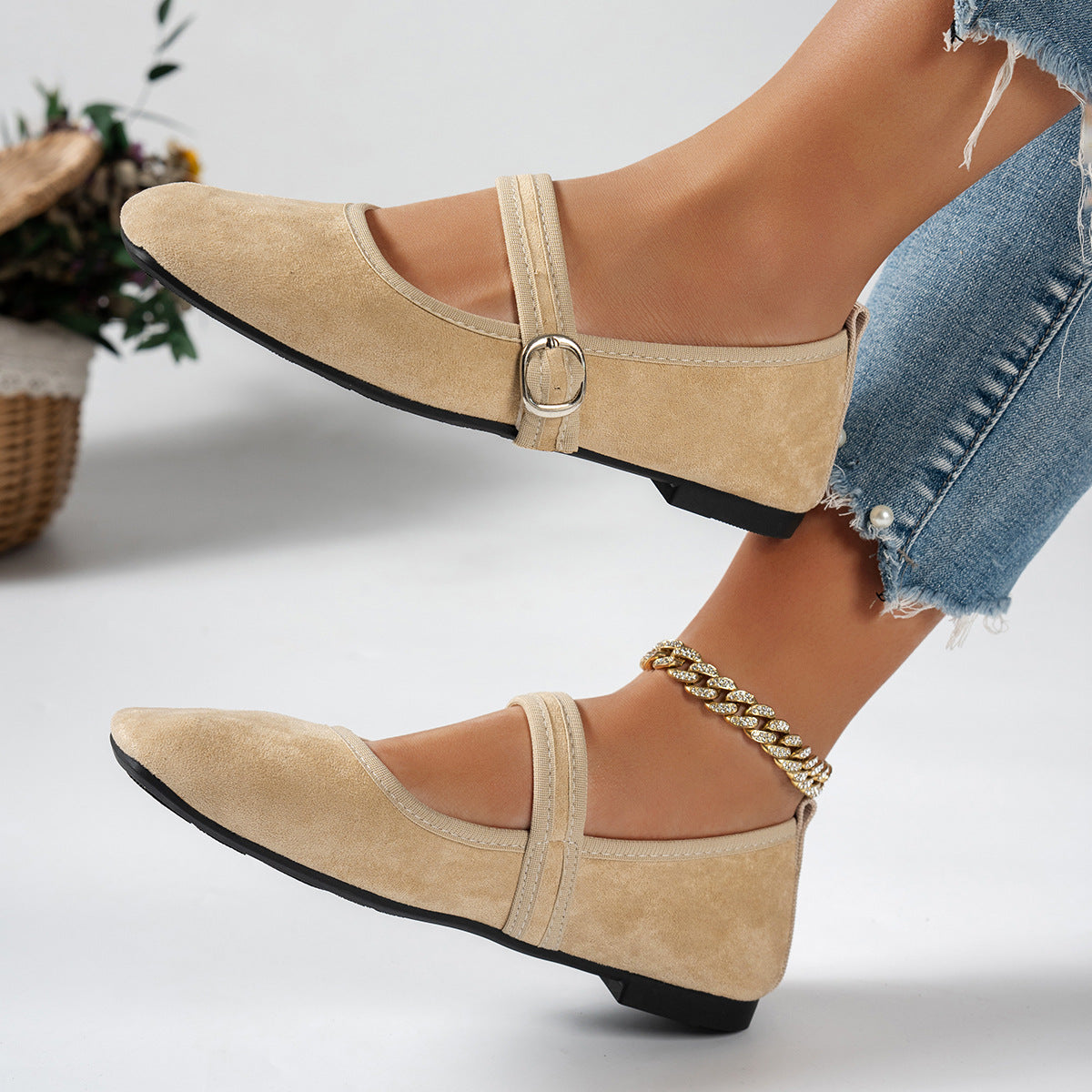 Beige women's Mary Jane flats with buckle straps, worn with jeans