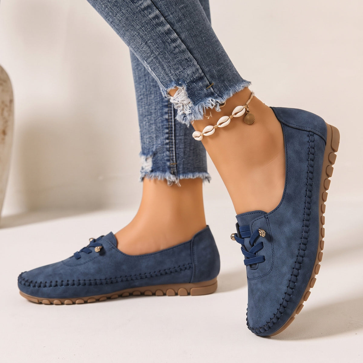 Navy women's wide fit suede loafers with brown soles, side view on feet