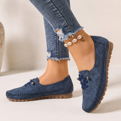 Navy women's wide fit suede loafers with brown soles, side view on feet