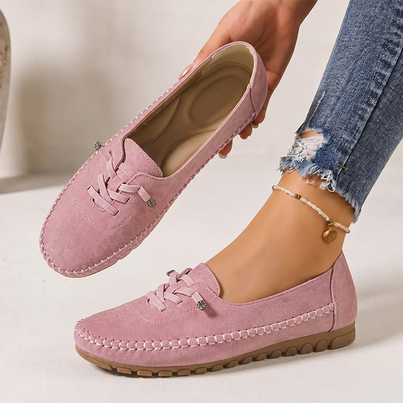 Pink women's suede loafers showing the shaped insole and decorative lacing