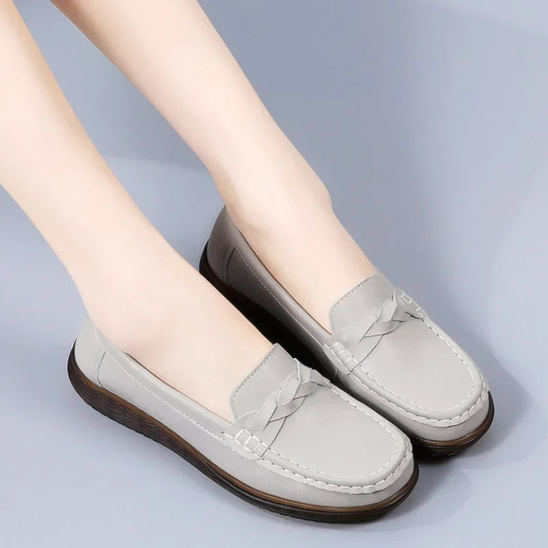 Black bow-detail loafers for women, angled on-foot studio view