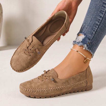 Tan women's suede loafers showing the shaped insole and decorative lacing