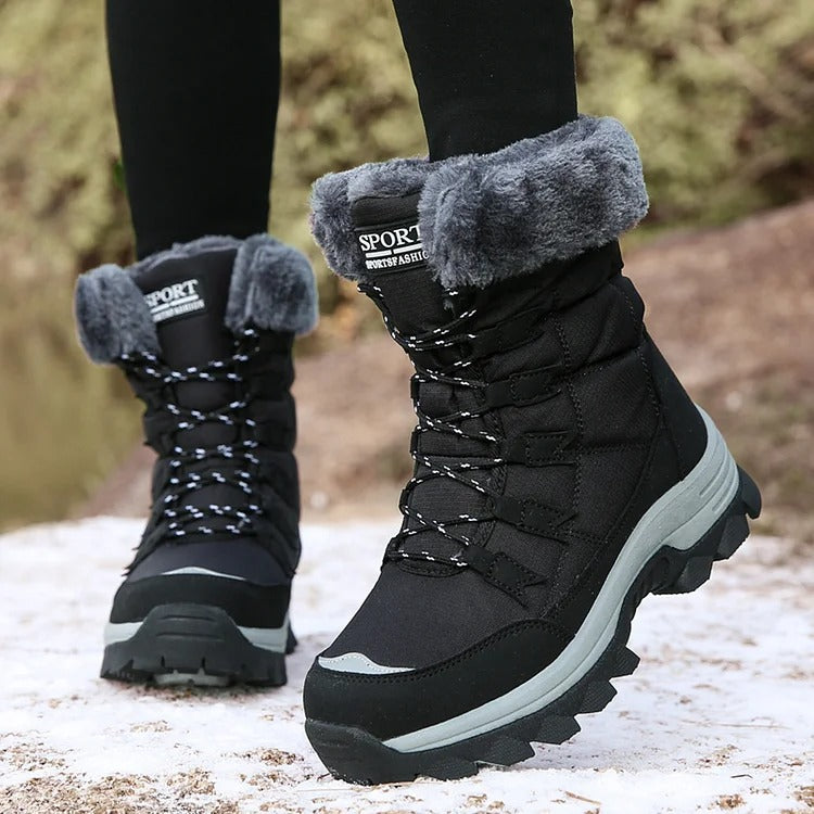 Black lace-up winter boots with grey fleece cuffs worn outdoors in snow