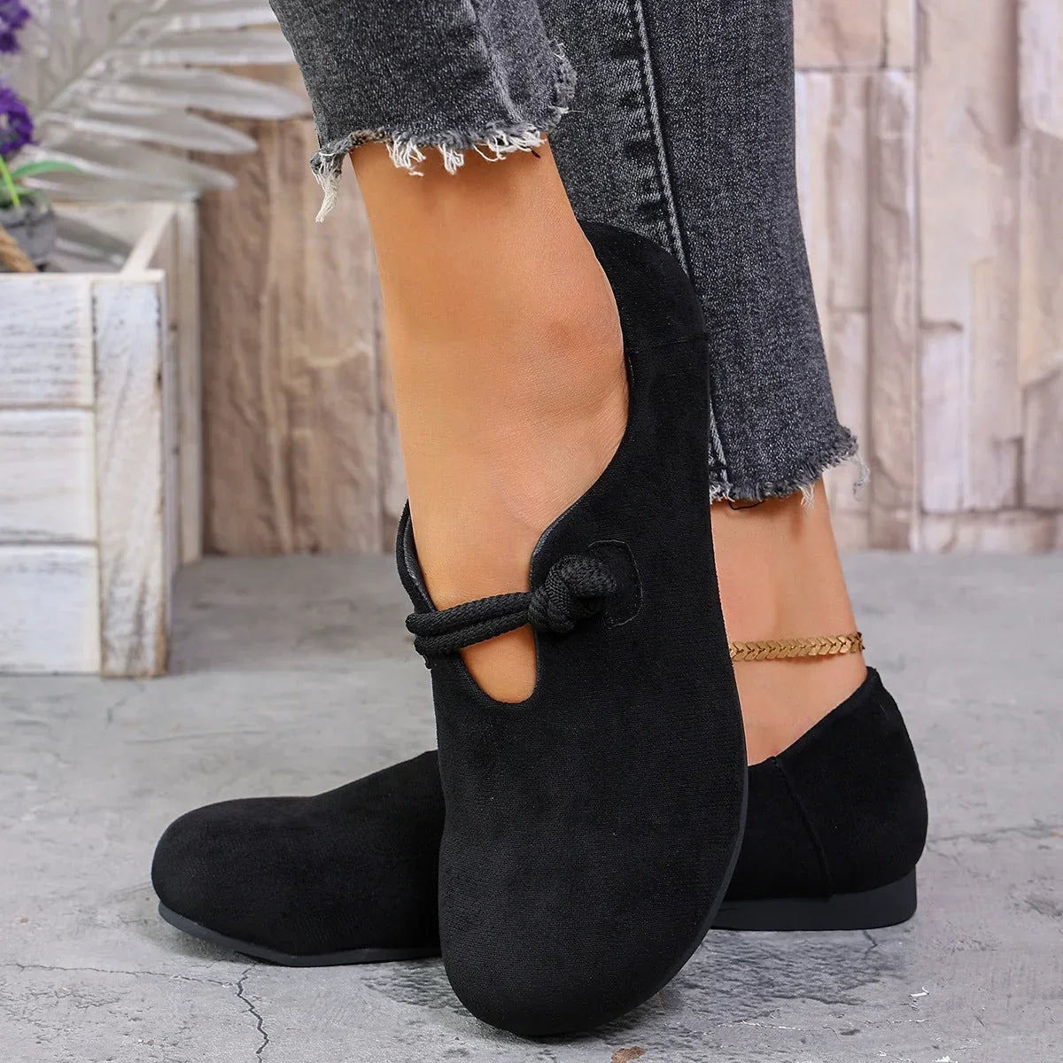 Black soft flats worn with jeans, side view