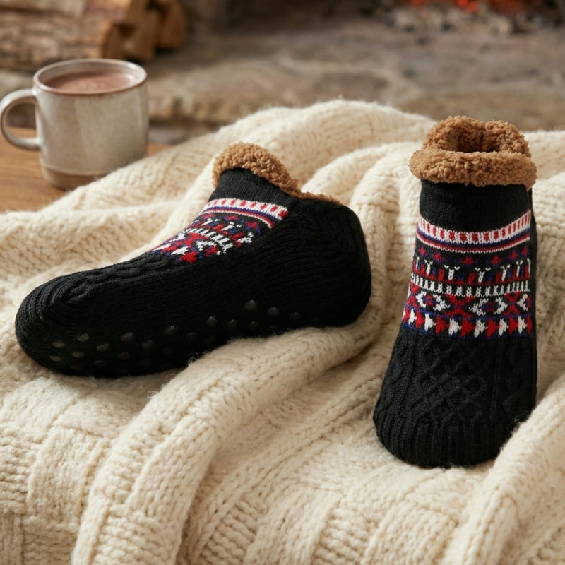 Auldweave unisex ultra-warm fleece-lined slipper socks – black pair beside a fireplace