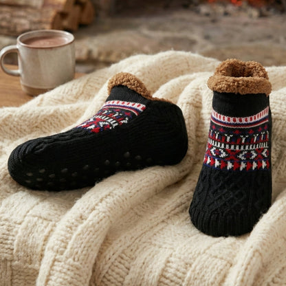 Auldweave unisex ultra-warm fleece-lined slipper socks – black pair beside a fireplace